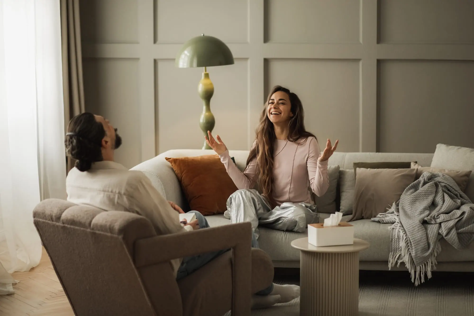 Woman and man sitting on couches, having good conversation